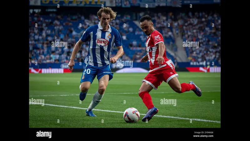Cầu thủ Espanyol với bóng trước sự truy cản của cầu thủ Rayo Vallecano Cầu thủ Espanyol với bóng trước sự truy cản của cầu thủ Rayo Vallecano
